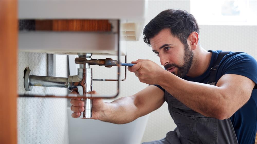 Plumber Fixing a Faucet